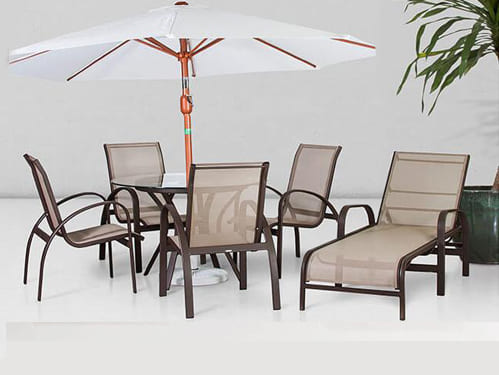 Um conjunto em tela sling com mesa e cadeira e ombrelone mais uma chaise 